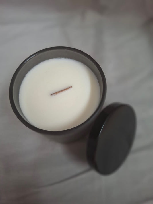 White scented candle in sleek black jar for relaxation and home décor